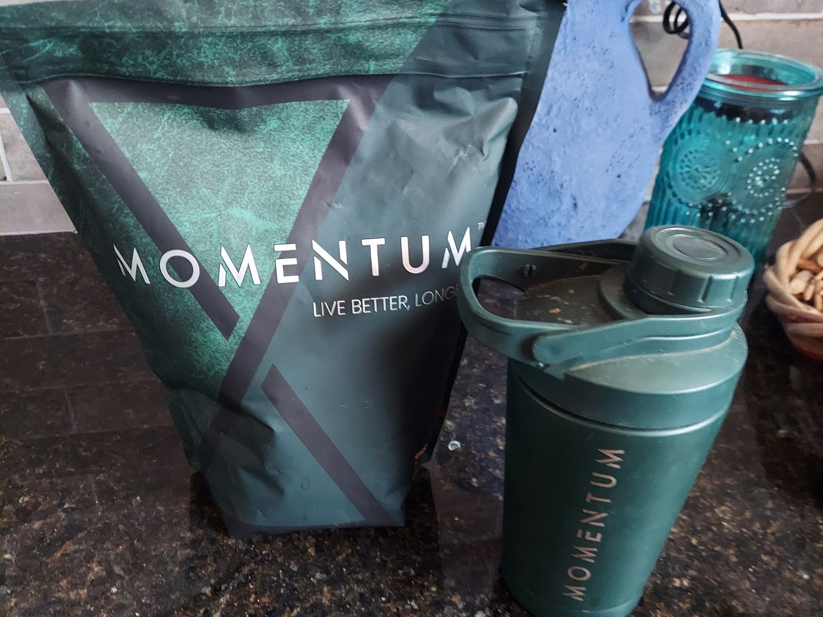 Momentum longevity shake pouch next to a used Momentum shaker bottle on a kitchen counter